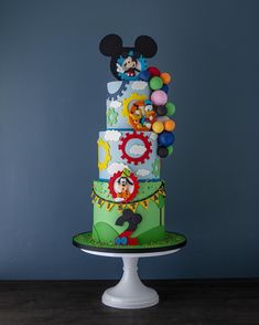 a three tiered cake with mickey mouse decorations