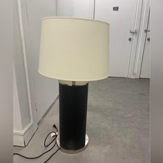 a lamp that is sitting on the floor in front of a door with a light plugged into it