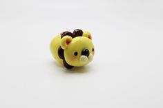 a yellow and brown bear figurine sitting on top of a white surface