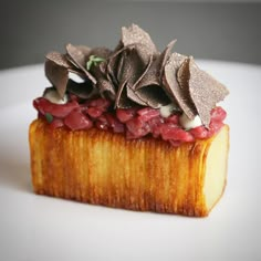 a piece of food on a white plate with silver leaves and other things around it