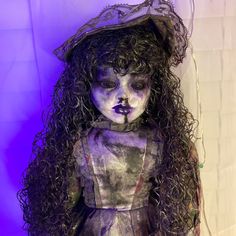 a creepy looking doll with long hair and makeup on it's face is standing in front of a purple background