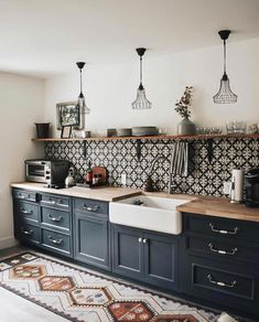 a kitchen with blue cabinets and an area rug