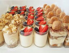 desserts and pastries are arranged on display in plastic containers, along with muffins and strawberries