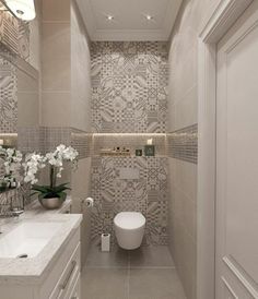 the bathroom is decorated in neutral tones with white flowers and greenery on the counter