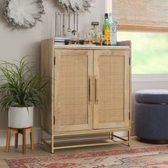 a small cabinet in the corner of a room with plants and bottles on top of it