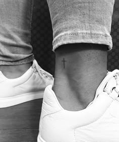 a person with a cross tattoo on their ankle and the other foot is shown in black and white