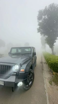 a jeep parked on the side of a foggy road