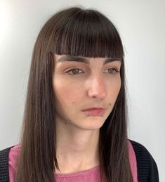 a woman with long brown hair and bangs