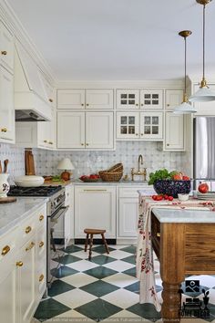 a kitchen with checkered flooring and white cabinets