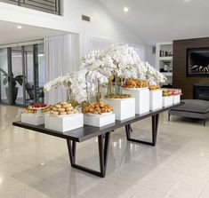 a table filled with white flowers and pastries on top of it's sides