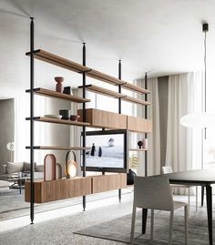 a living room filled with furniture and a flat screen tv mounted on a wall next to a dining table