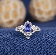 a blue and white diamond ring on top of a blue cloth