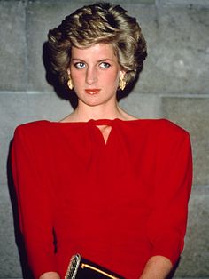 a woman in a red dress is holding a book