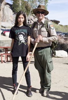 a man standing next to a woman holding a stick