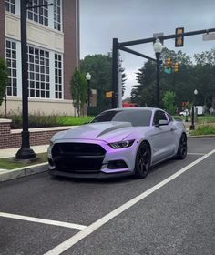 a purple car is parked on the side of the road in front of a traffic light