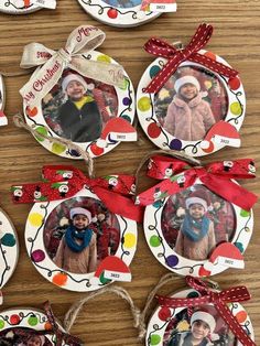 christmas ornaments are arranged on a table with pictures hanging from the top and around them