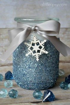 a glass jar filled with glitter and a snowflake ornament on top