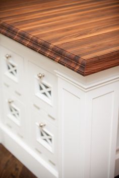 a kitchen island made out of wood and white cabinets