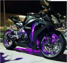 a purple motorcycle parked on the street at night