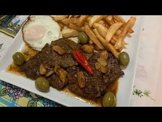 a white plate topped with meat and french fries