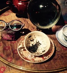 a table topped with two cups and saucers filled with dirt on top of it