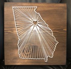 a string art piece with the shape of indiana in it's center, on a black leather chair