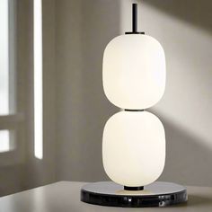 a white table lamp sitting on top of a wooden table