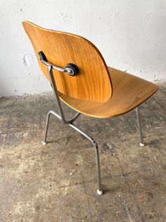 a wooden chair sitting on top of a cement floor