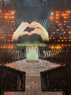 the stage is set up for a concert with two hands in the shape of a heart