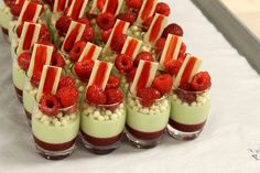 desserts with strawberries and white chocolate are arranged in small cups on a table