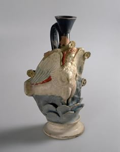 a ceramic vase sitting on top of a white table next to a gray wall and floor