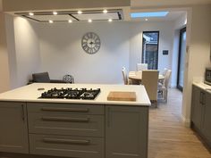 a kitchen with a stove top oven sitting under a clock