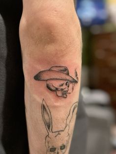 a person with a tattoo on their leg has a skull and mushroom in the shape of a rabbit