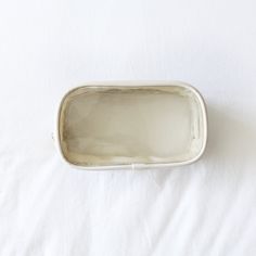 an empty silver tray sitting on top of a white sheet