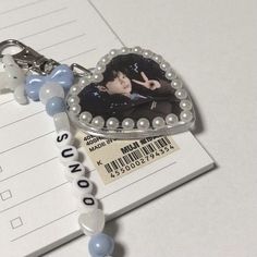 a keychain with a photo on it sitting next to a notepad and pen