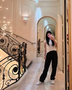 a woman taking a selfie while standing in front of a staircase with lights on it