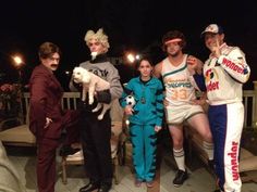 four people dressed up in costumes posing for a photo with one person holding a dog