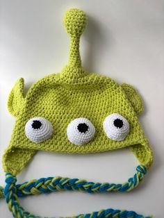 a crocheted hat with eyes and a rope