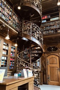 a spiral staircase in a library with bookshelves