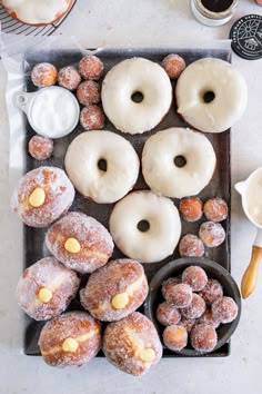 doughnuts are arranged on a tray with coffee and other pastries around them