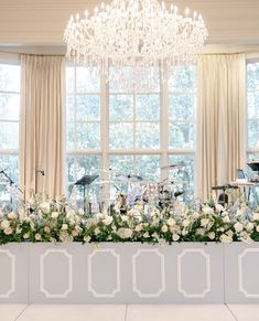 an elegant wedding setup with white flowers and music instruments in front of a large window