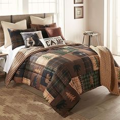 a bed in a bedroom with plaid comforter and pillows