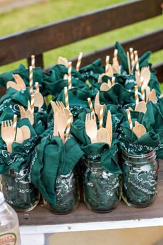 mason jars filled with forks and green napkins