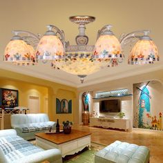 a living room filled with furniture and a large chandelier above the couches