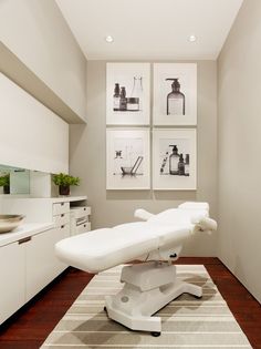 a white chair sitting on top of a wooden floor in front of pictures hanging on the wall