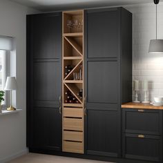 a kitchen with black cupboards and wooden counter tops next to a white brick wall