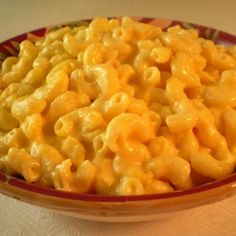 a bowl filled with macaroni and cheese on top of a table