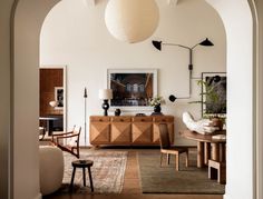 a living room with an archway leading into the dining area