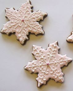 three decorated cookies sitting on top of a table