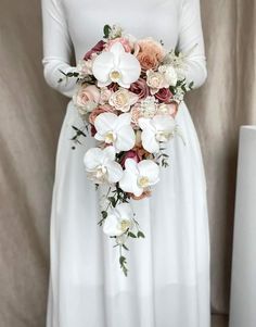 a woman in a white dress holding a bouquet of flowers